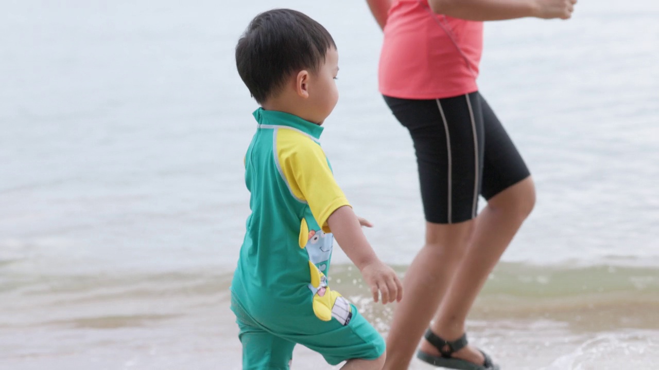 在海滩上玩海浪的男孩视频素材