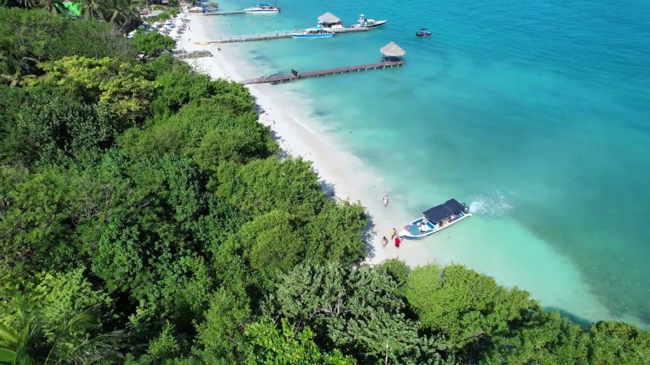 鸟瞰卡塔赫纳罗萨里奥岛美丽的风景，游船和人们在大海和海滩上游泳。视频素材