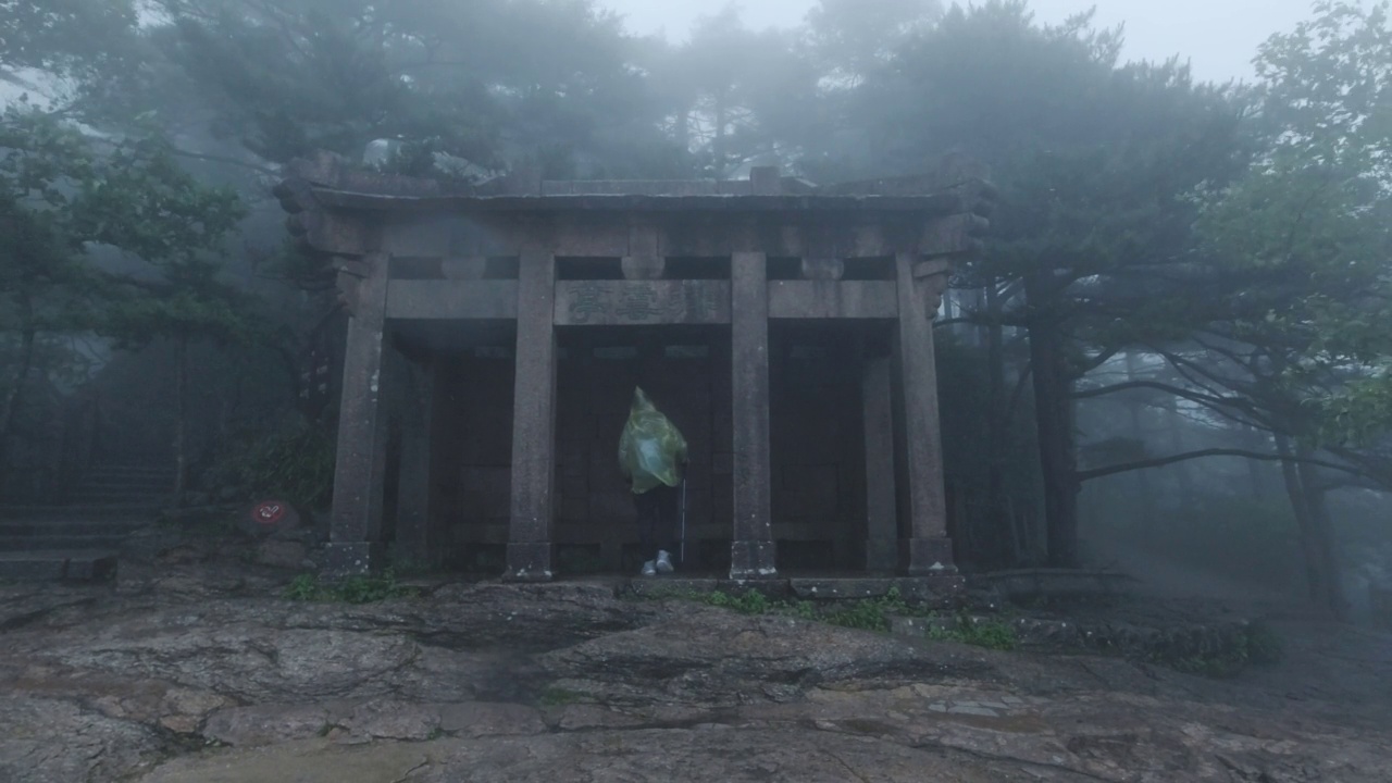 中国安徽黄山，游人在雨中经过亭子视频素材画面1