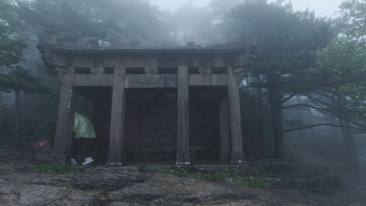中国安徽黄山，游人在雨中经过亭子视频素材画面1