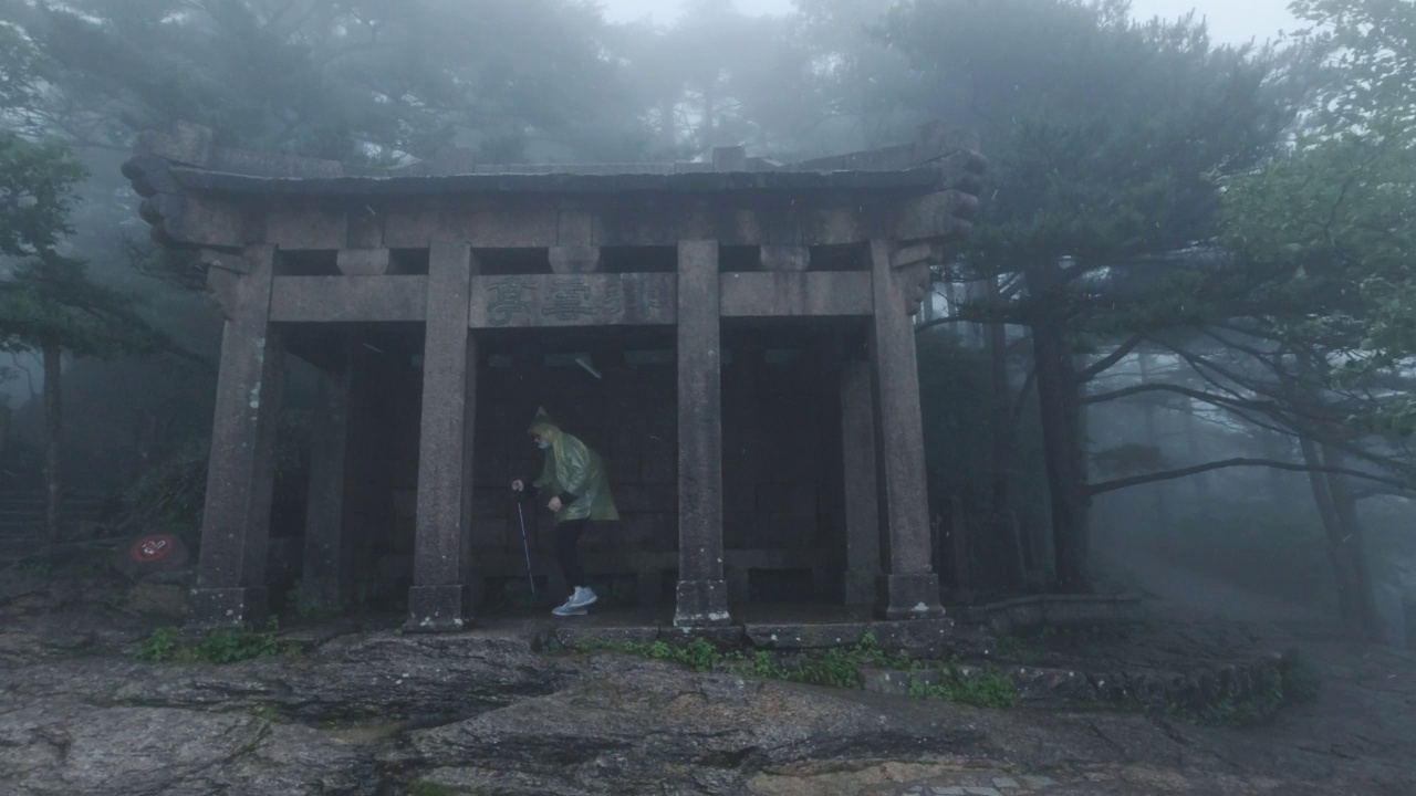 中国安徽黄山，游人在雨中经过亭子视频素材画面3