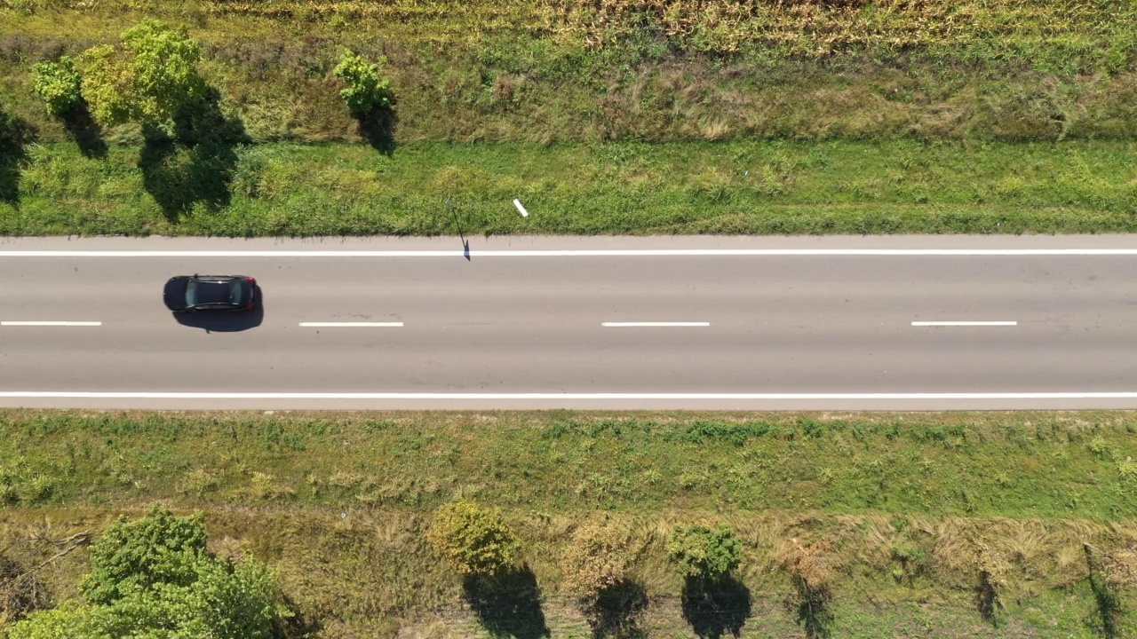 空中拍摄的卡车、自行车和汽车在路上穿过夏天的乡村景观视频素材