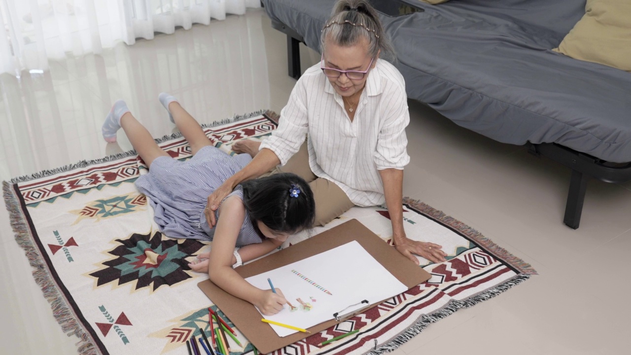 奶奶和妈妈在客厅教可爱的女儿，女孩，
孙女，祖母，学习概念。视频素材