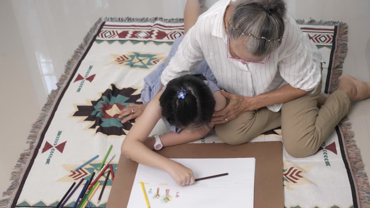 奶奶和妈妈在客厅教可爱的女儿，女孩，
孙女，祖母，学习概念。视频素材