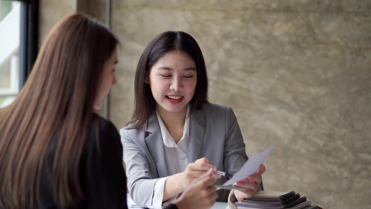 亚洲女领导在会议上用电脑教学指导业务团队，女高管解释在线项目谈话，帮助年轻同事在办公室咨询客户。视频素材