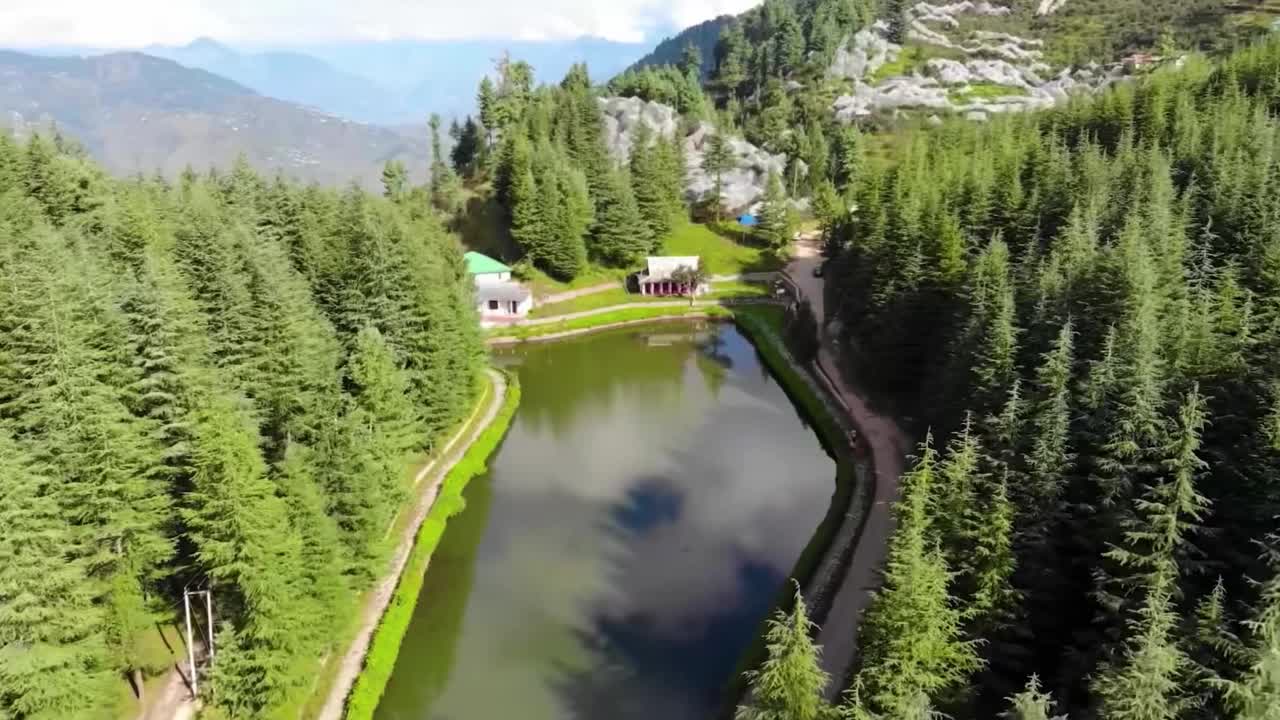 鸟瞰森林中的湖泊，平静的湖面上倒映着胡德山的倒影。视频素材