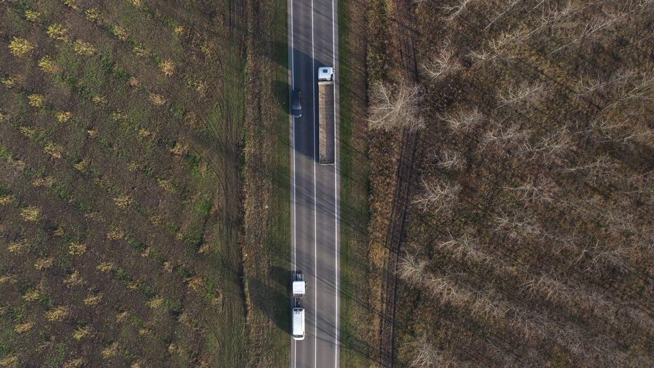 自上而下航拍各种车辆在公路上穿越乡村景观，无人机拍摄视频素材