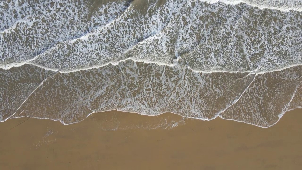 沿着海岸线的海滩和海浪的鸟瞰图视频素材