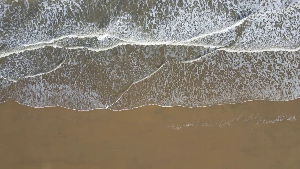 沿着海岸线的海滩和海浪的鸟瞰图视频素材