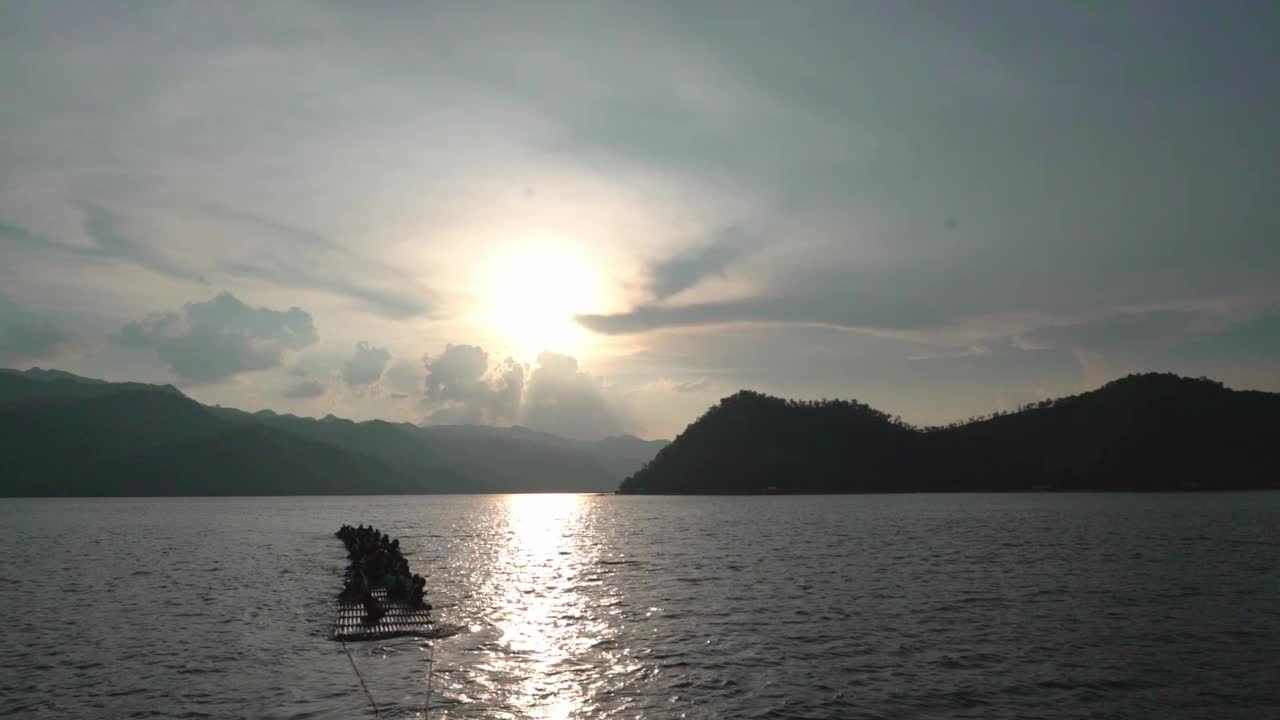 汽艇在开阔的水面上缓缓行驶，背景是山岛。视频素材