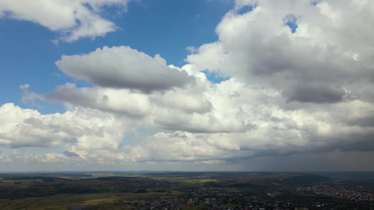 高空鸟瞰图，远处的城市被暴雨前形成的蓬松积云所覆盖视频素材