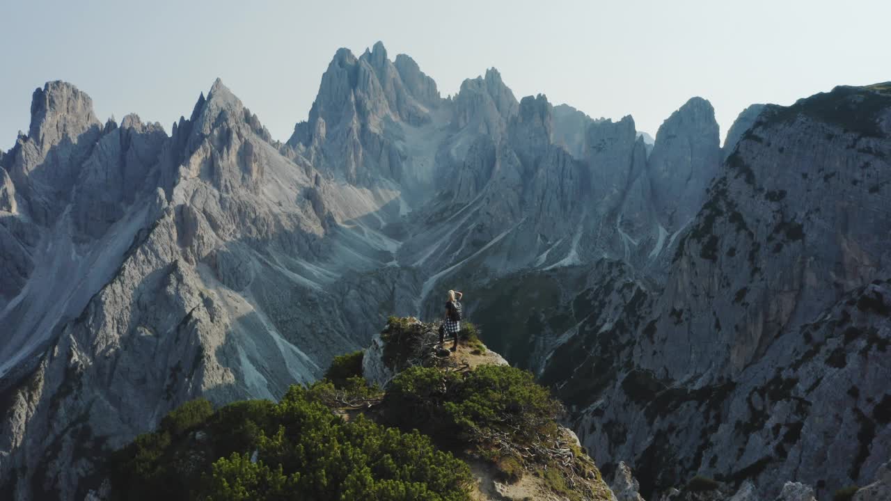 白云石山脉,意大利。女徒步旅行者欣赏美丽的Auronzo di Cadore峰的卡迪尼迪米苏拉纳山脉组。勒瓦雷多Tre Cime di Levaredo国家公园和联合国教科文组织世界遗产。空中无人机视频视频素材