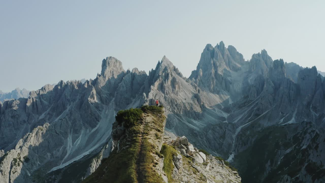 白云石山脉,意大利。人在山顶。背景是卡迪尼迪米苏拉纳山脉的顶峰。勒瓦雷多Tre Cime di Levaredo国家公园和联合国教科文组织世界遗产。空中无人机视频视频素材