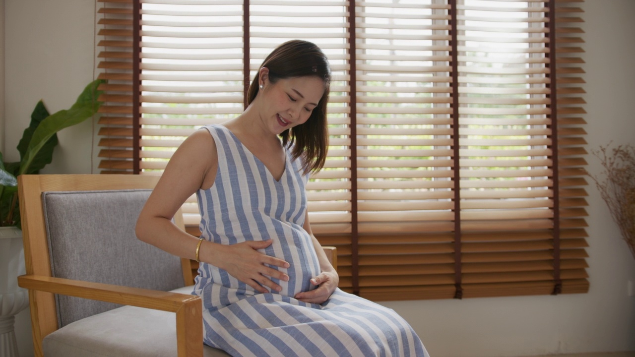 孕妇轻抚肚子，等待家中最美妙的时刻视频素材