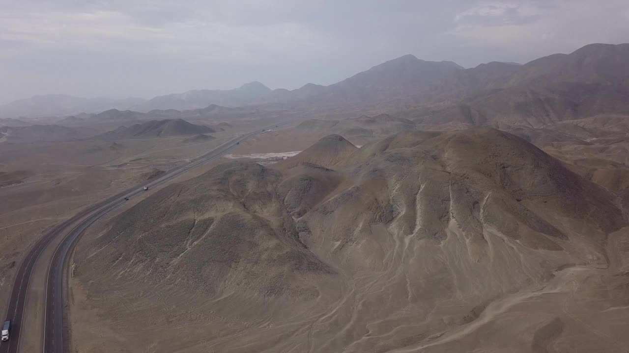 无人机拍摄的沙漠中一座大山旁边的公路与汽车机智视频素材