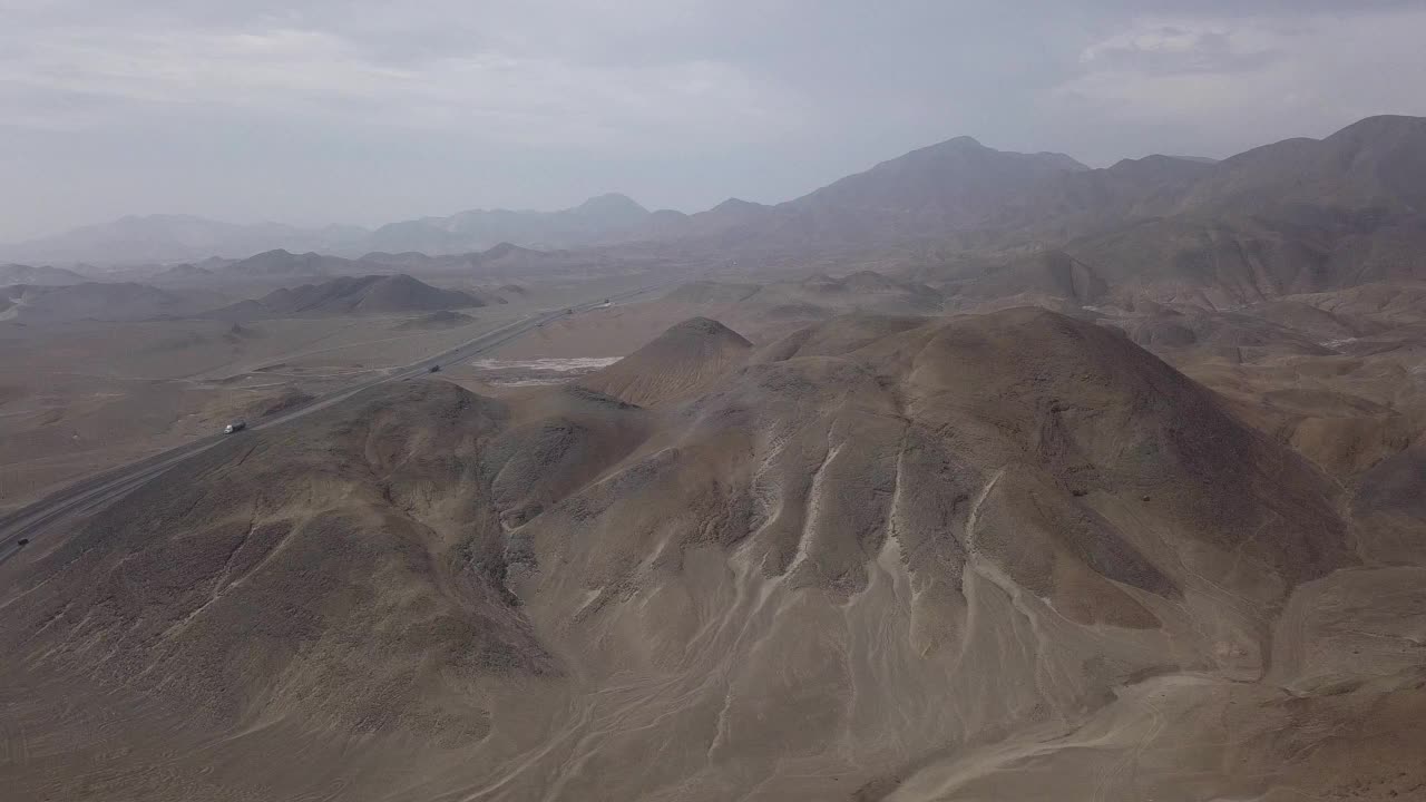 无人机拍摄的沙漠中一座大山旁边的公路与汽车机智视频素材