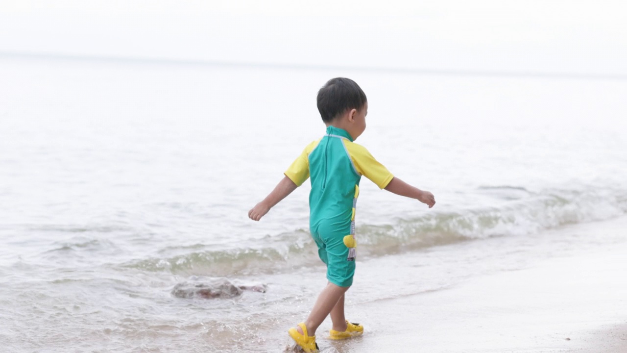 在海滩上玩海浪的男孩视频素材