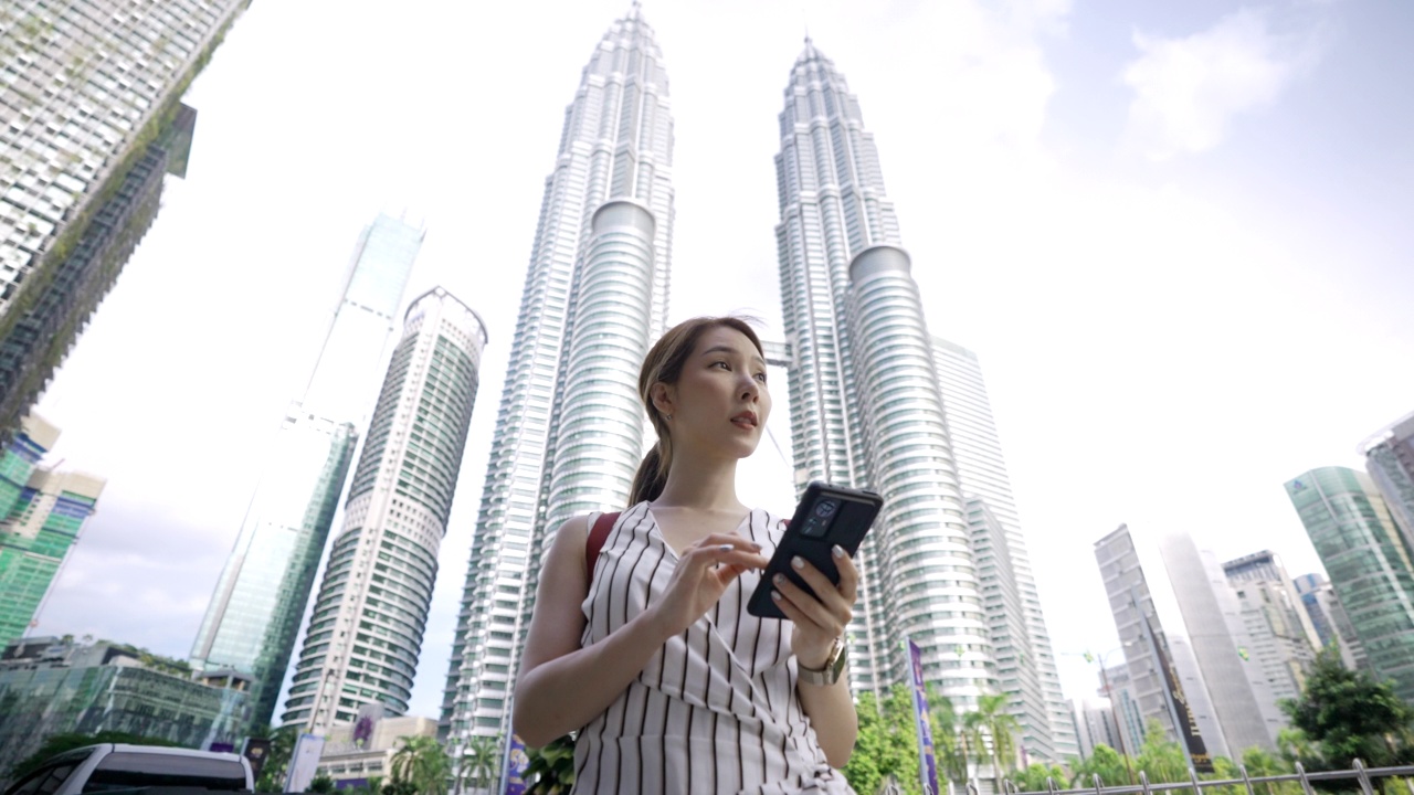 一名亚洲女性在吉隆坡市中心旅行时使用智能手机视频素材