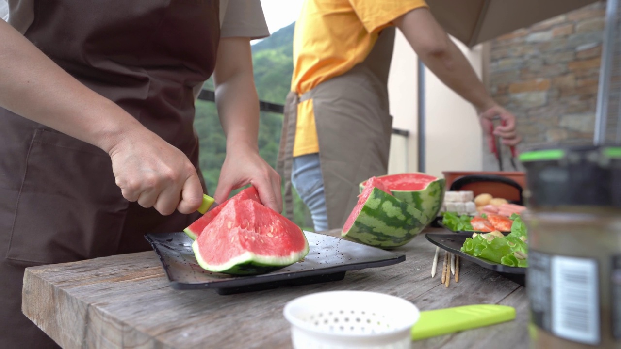 一个女人的手在露天桌子上切西瓜视频素材