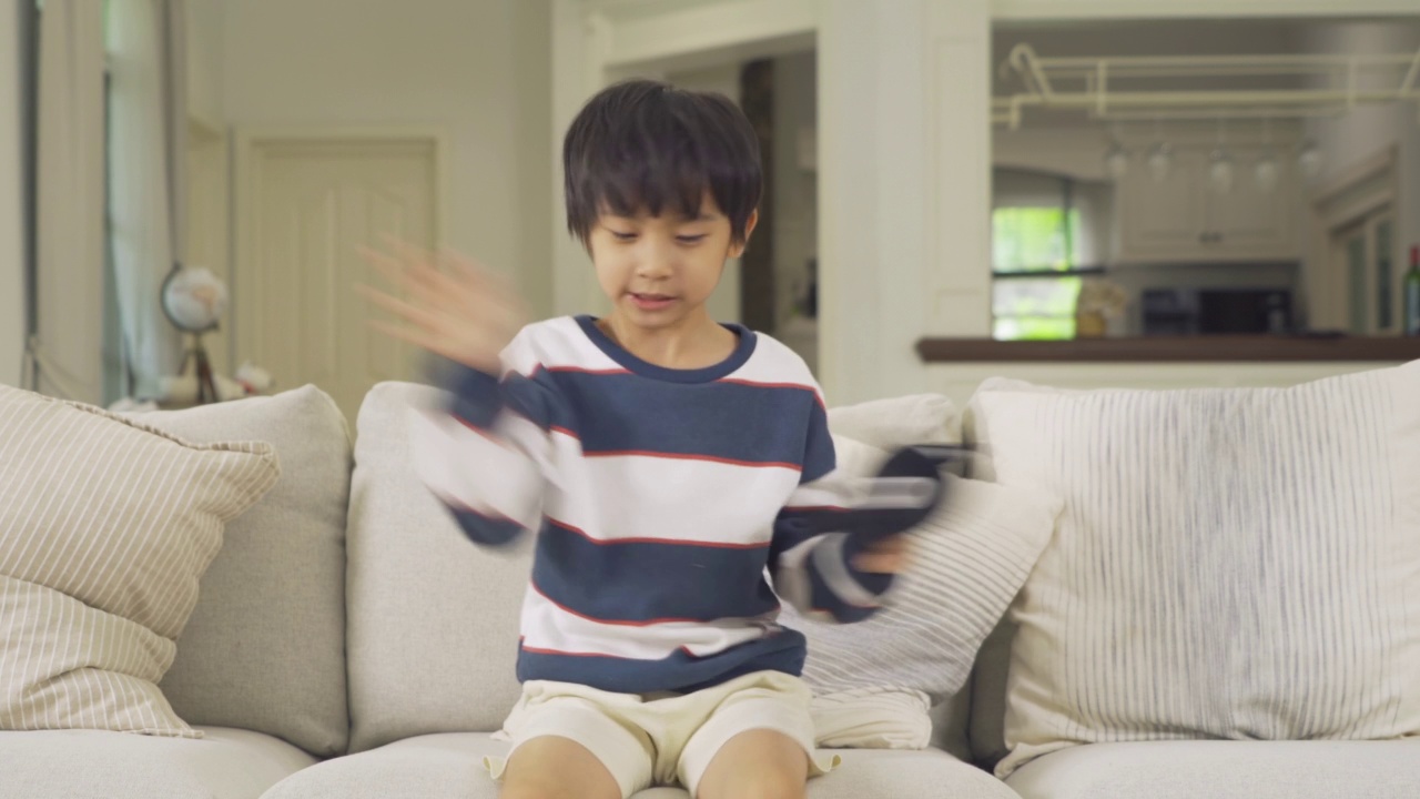 幸福微笑的肖像，年轻的亚洲学生男孩呆在家里或房子。人们的生活方式。教育。视频素材画面3