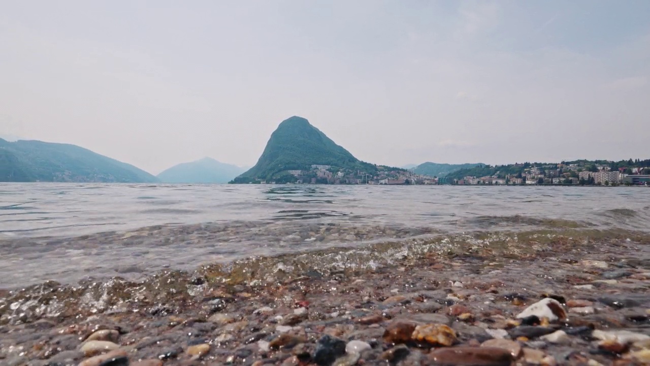 小波浪拍打着海岸。卢加诺湖视频素材