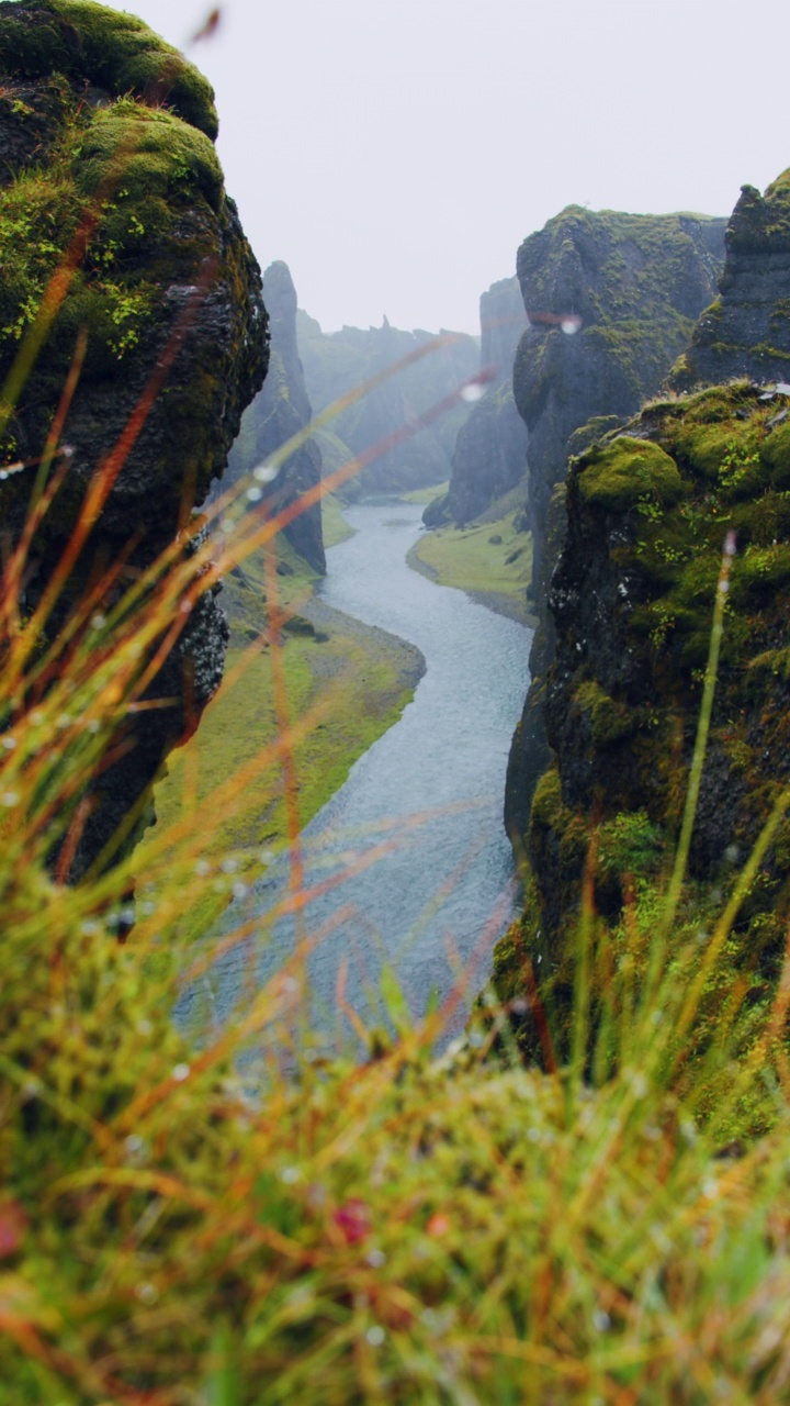 Fjadrargljufur峡谷遭遇暴雨天气。峡谷中崖壁岩层奇异陡峭，河流蜿蜒曲折。冰岛、欧洲视频素材