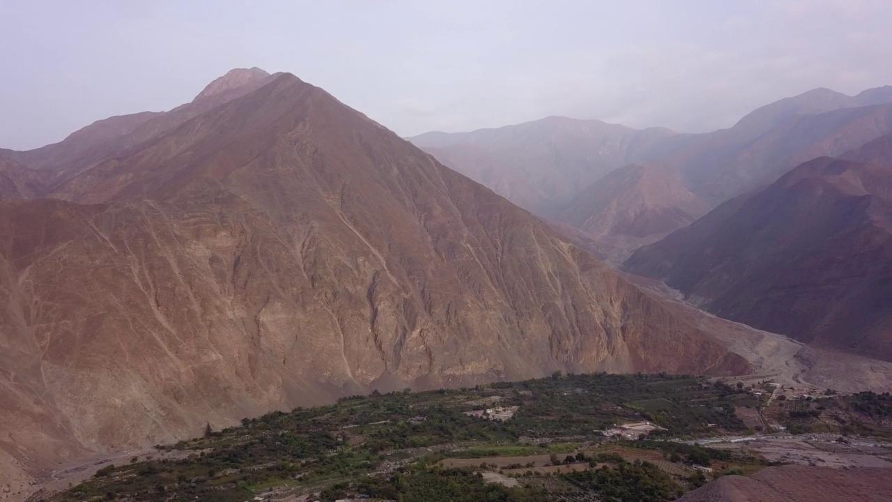 无人机在L高地的一个村庄的群山之间进行全景拍摄视频素材