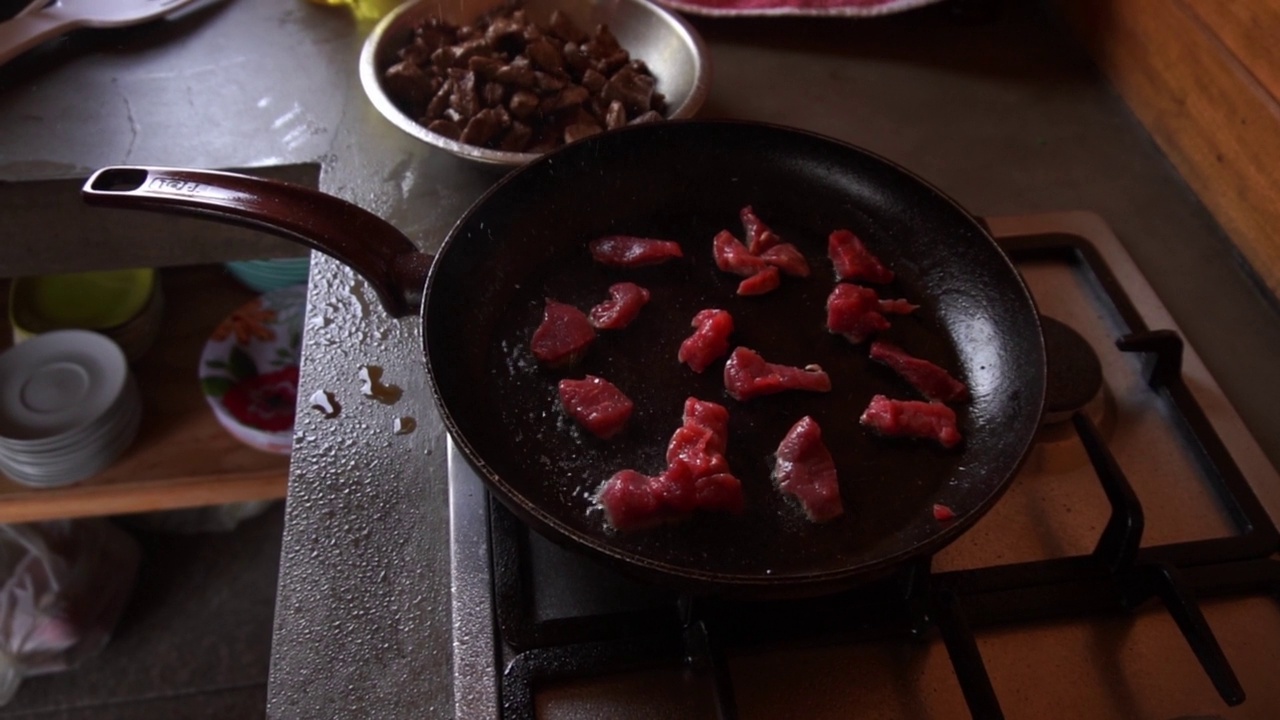 慢动作特写烹调小块红肉在锅里溅油一枚视频下载