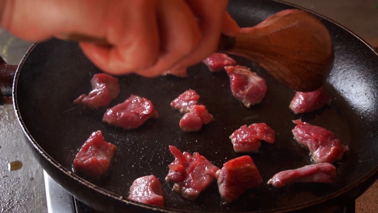 慢动作烹饪小块肉在锅里溅油视频下载