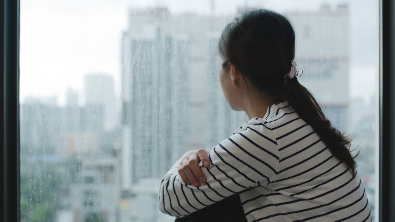 悲伤忧郁的年轻女子坐在窗边视频素材