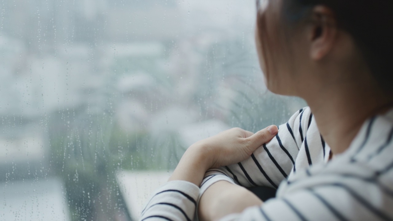 悲伤忧郁的年轻女子坐在窗边视频素材