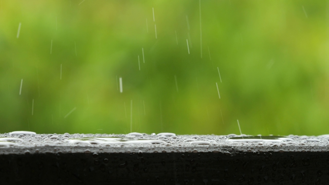 平静放松的冥想和平的背景。慢动作雨滴在大雨中滴落。雨天与大自然中的雨水。雨滴在阳台木栏杆上。视频素材