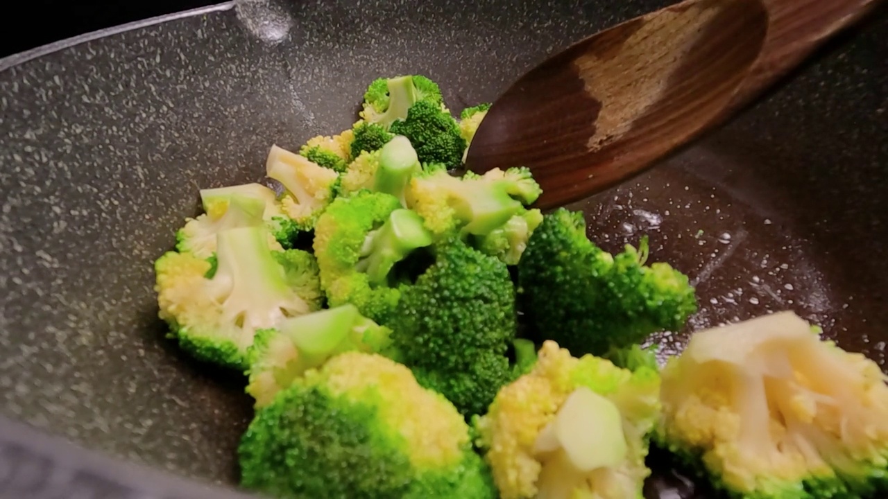 市场上新鲜的西兰花sautéed放在热煎锅里。视频素材画面1