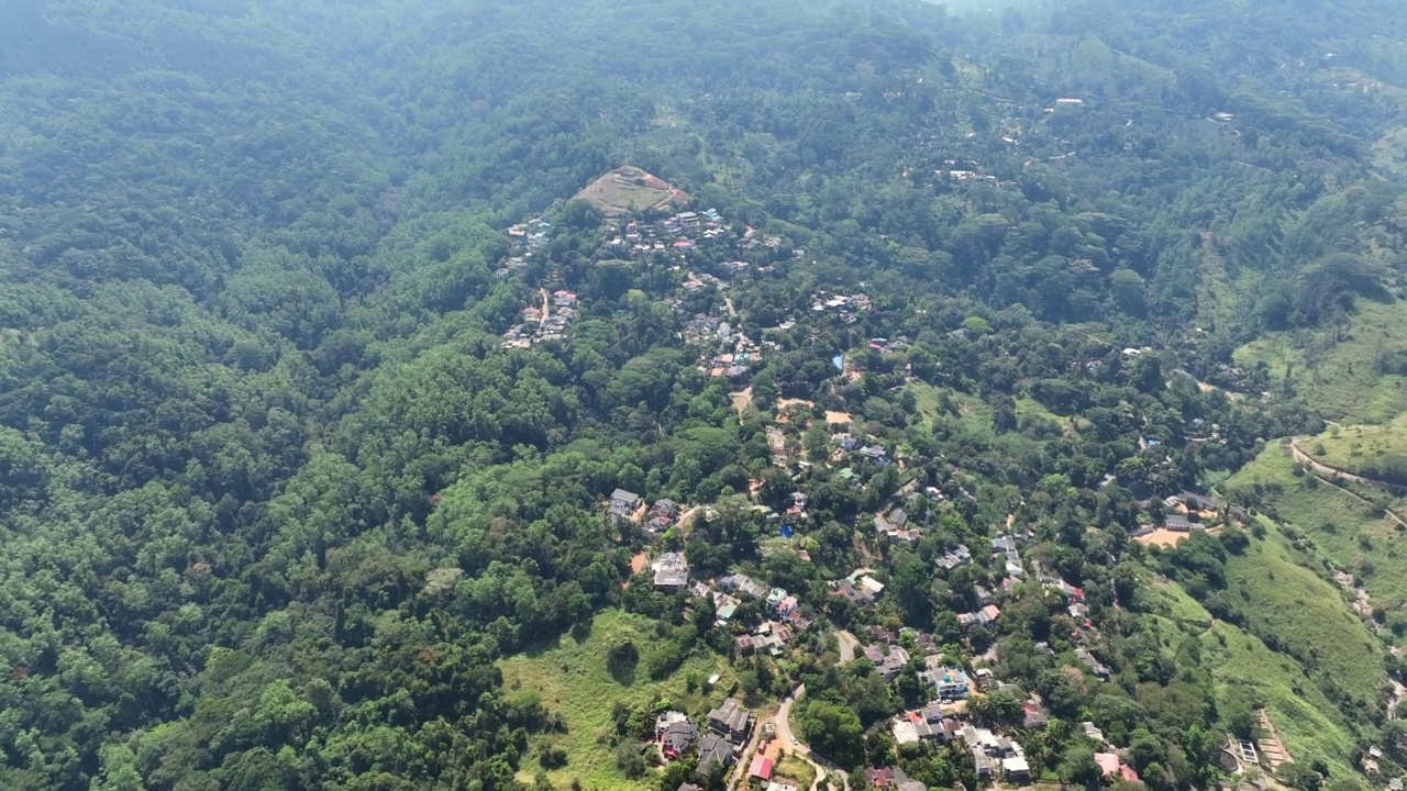 空中拍摄的绿色山脉上的住宅，无人机在晴朗的日子里向前飞行-康提，斯里兰卡视频素材