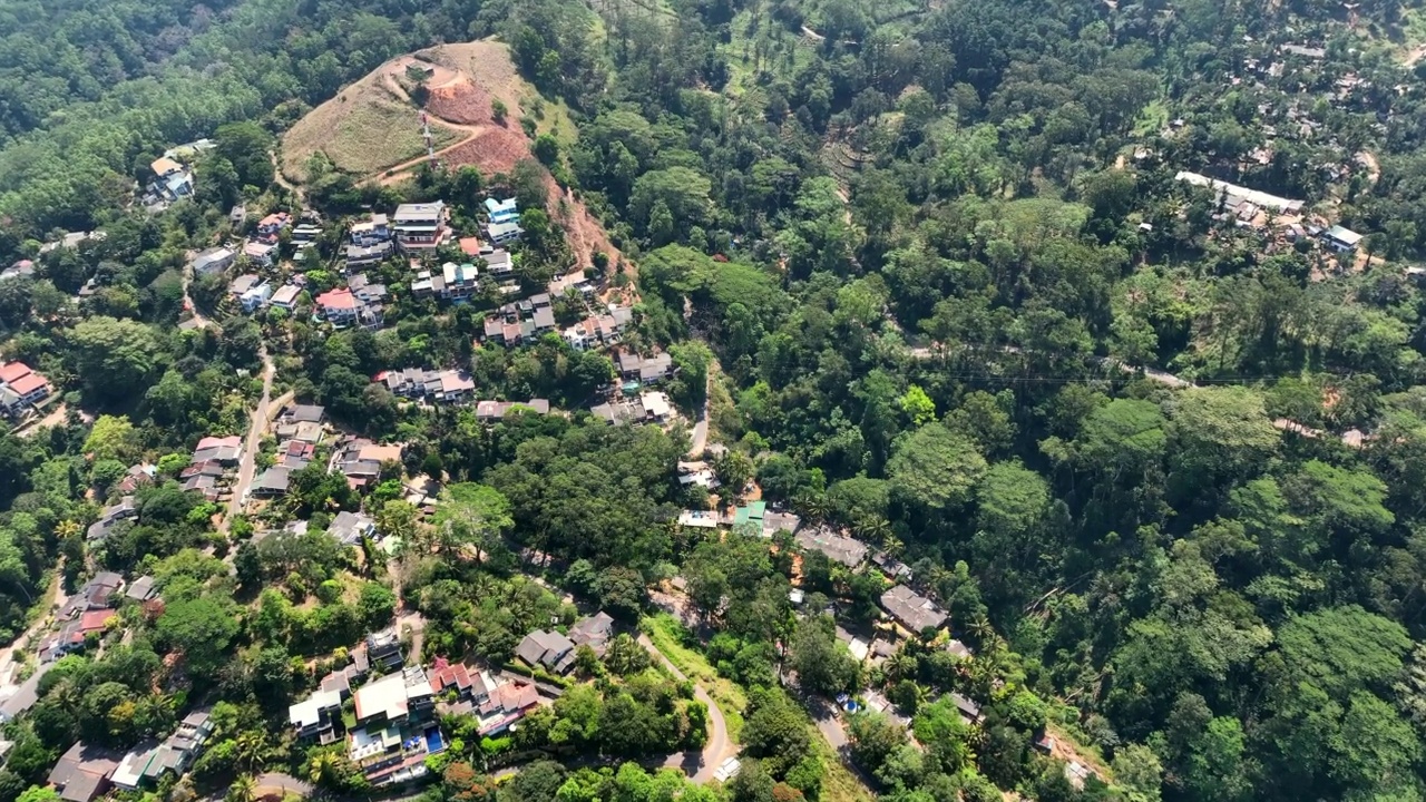 空中向前倾斜拍摄山上绿树中的住宅-斯里兰卡康提视频素材