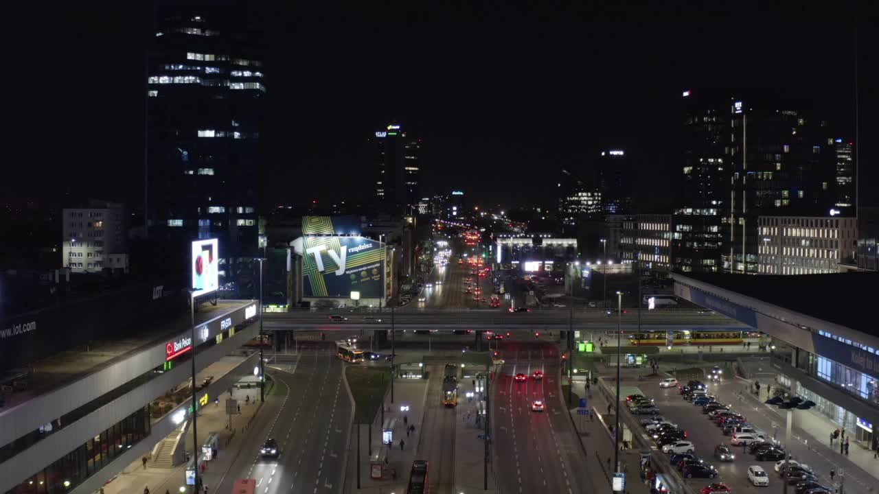 在中央火车站大楼周围的宽阔街道上向后飞行。市中心的夜间交通。波兰华沙视频素材