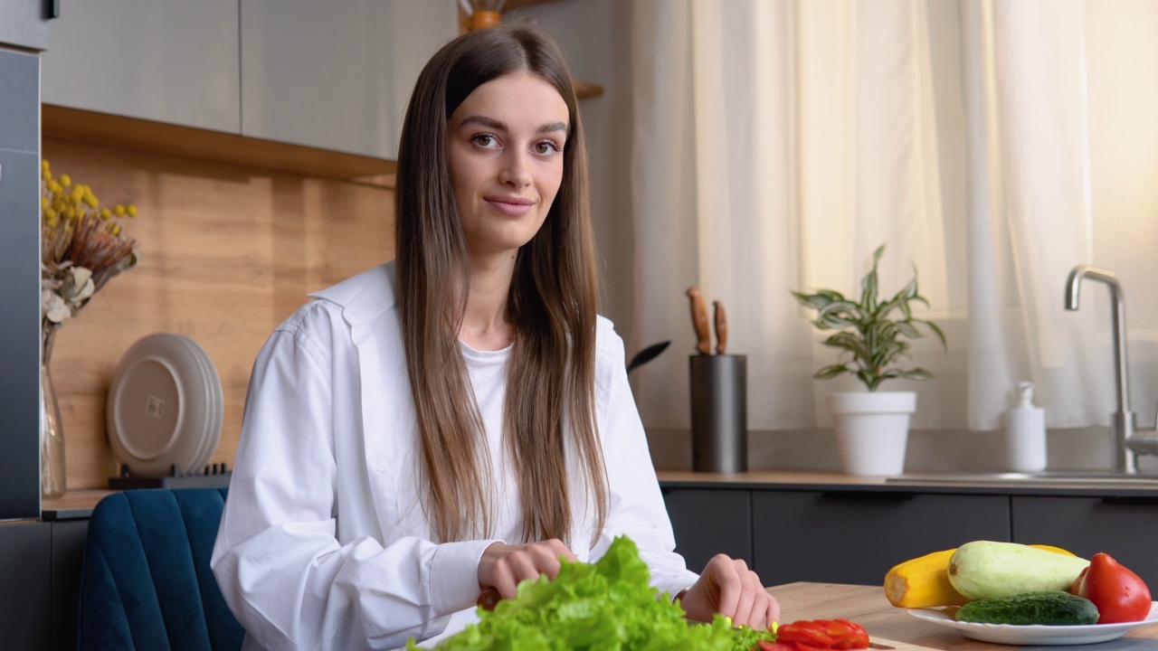 健康食品。素食沙拉。饮食。美丽的年轻女子正在厨房里准备蔬菜沙拉。节食的概念。健康的生活方式。在家做饭视频素材