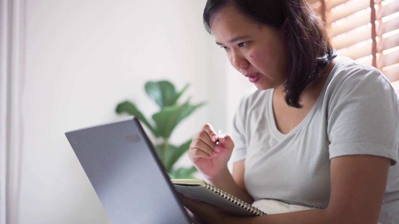 精力集中的女人早上在床上上网学习视频素材