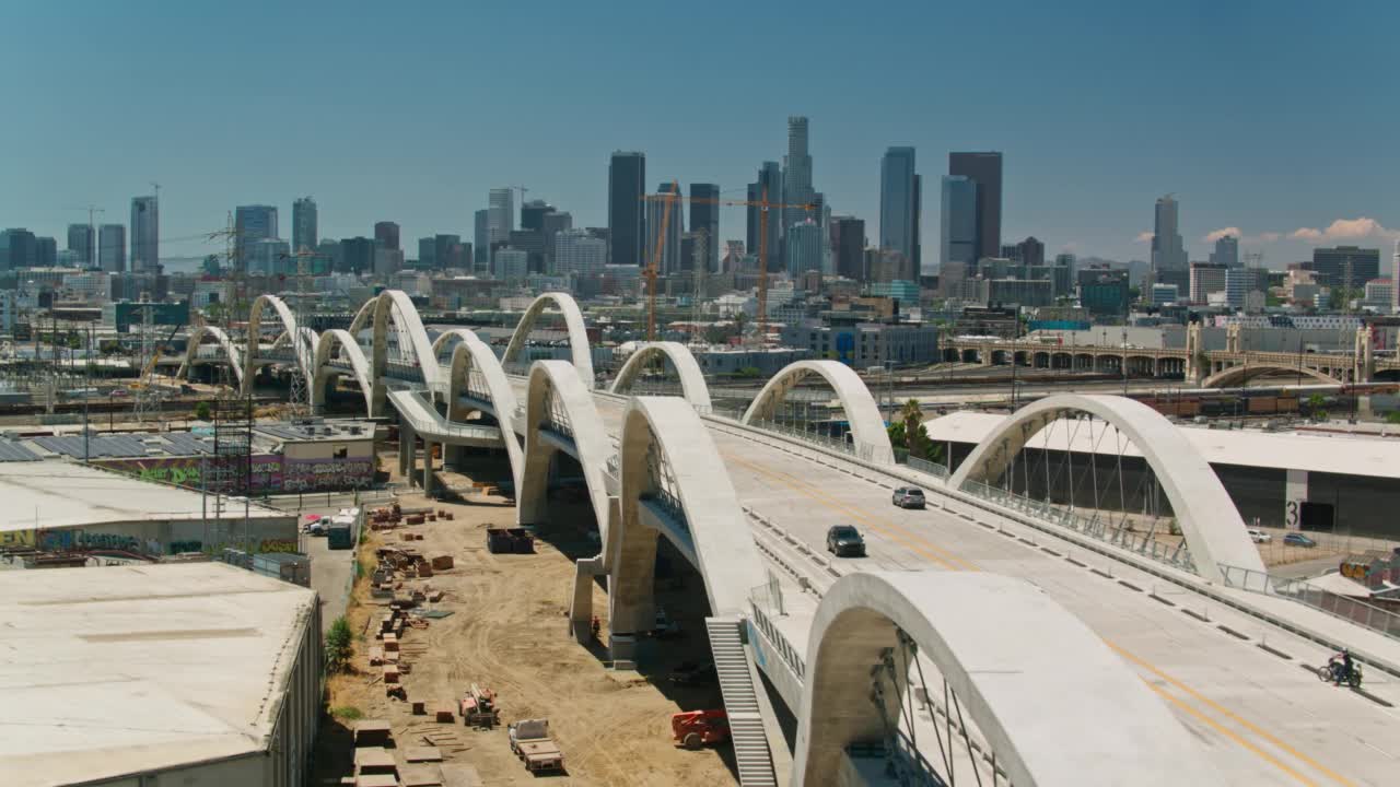 空中拍摄的汽车行驶在第六街大桥与洛杉矶市中心，加州在远处视频素材