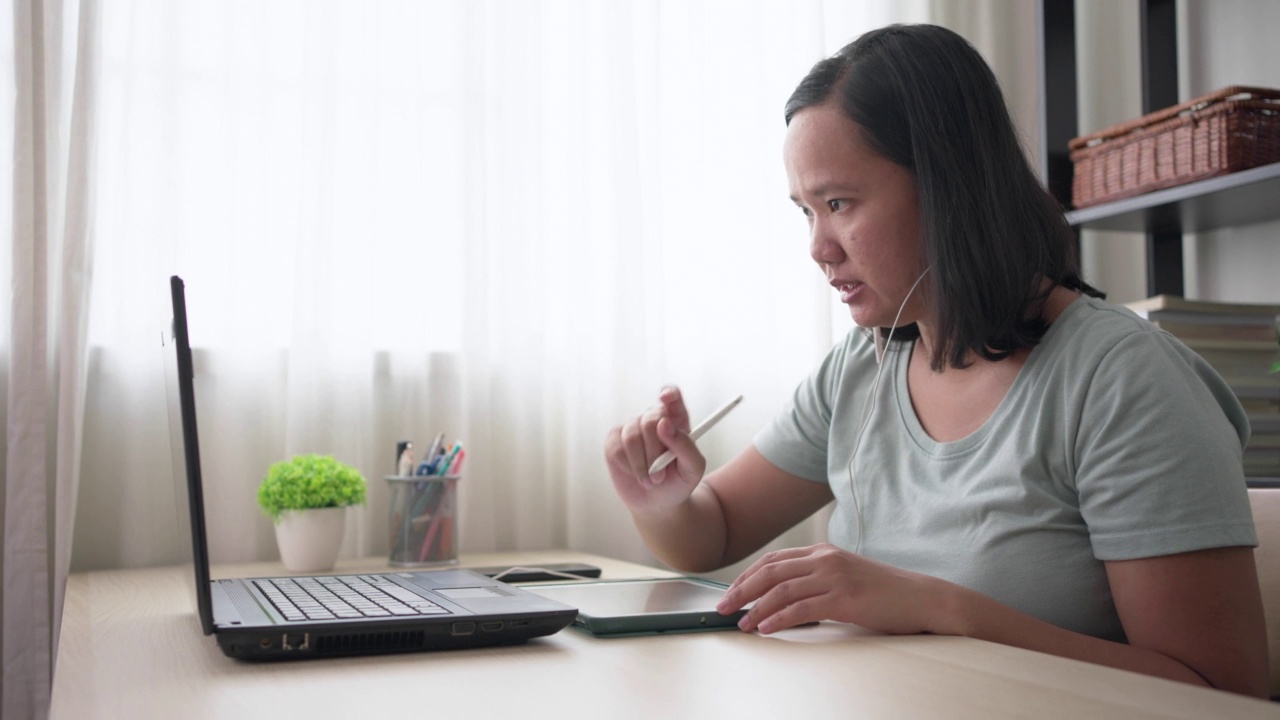 年轻的亚洲女性正在学习在线课程视频素材