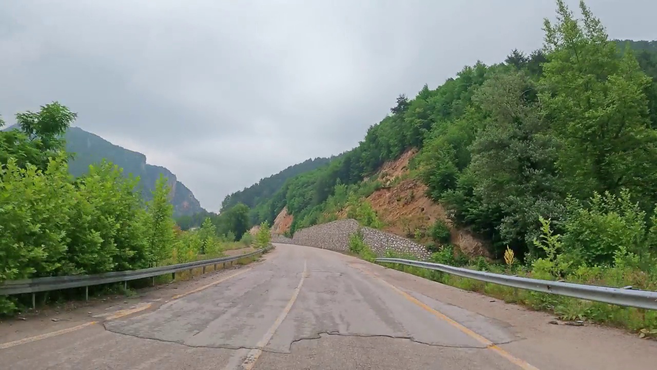 沿着森林的道路行驶。镜头拍摄于行驶在美丽空旷的道路上。时间流逝视频素材画面3