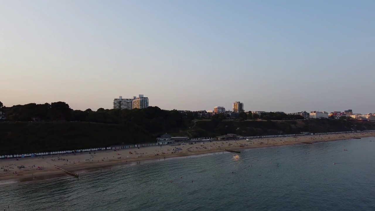 高角度海景海滩前与人在英国伯恩茅斯市，英国海洋的航拍镜头视频素材