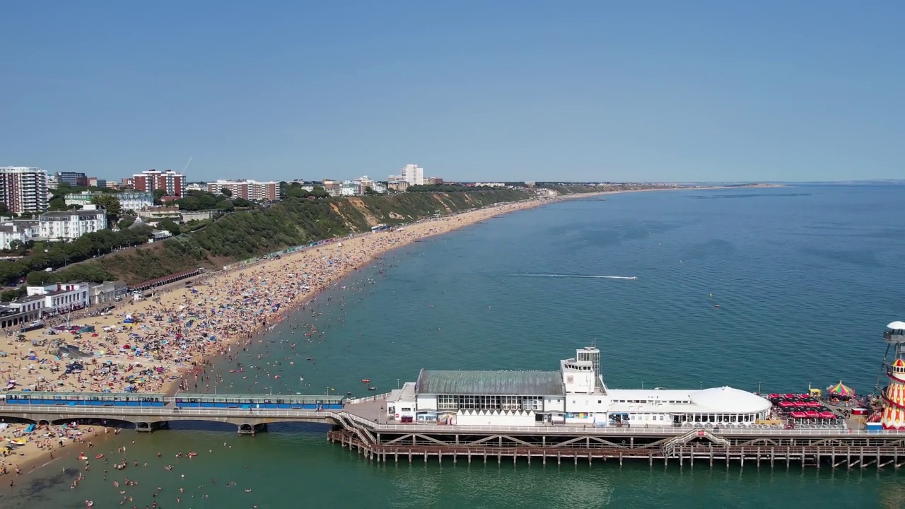 高角度海景海滩前与人在英国伯恩茅斯市，英国海洋的航拍镜头视频素材