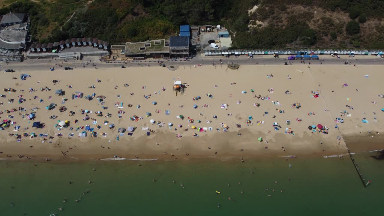 高角度海景海滩前与人在英国伯恩茅斯市，英国海洋的航拍镜头视频素材