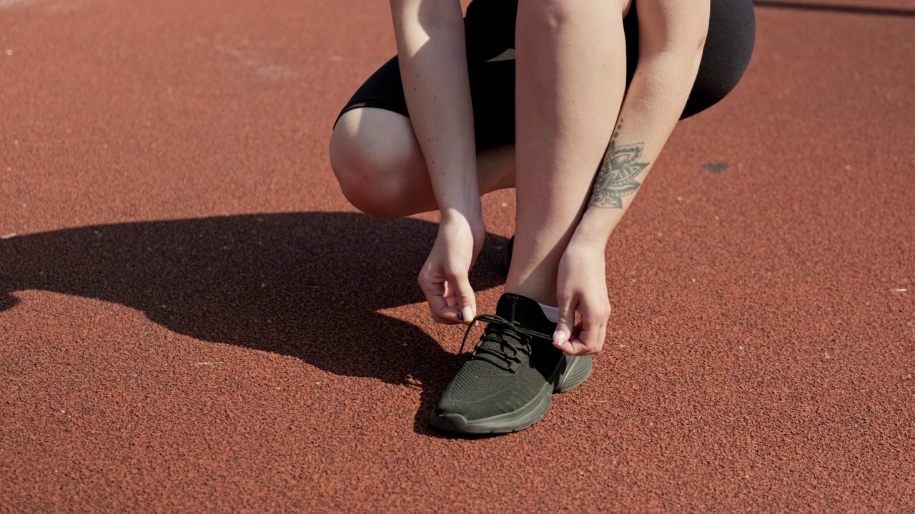 女人系鞋带。运动女性系黑色运动鞋视频素材