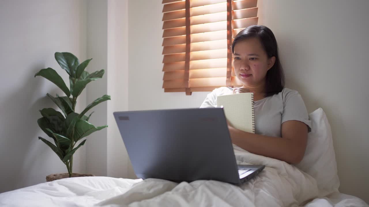 精力集中的女人早上在床上上网学习视频素材