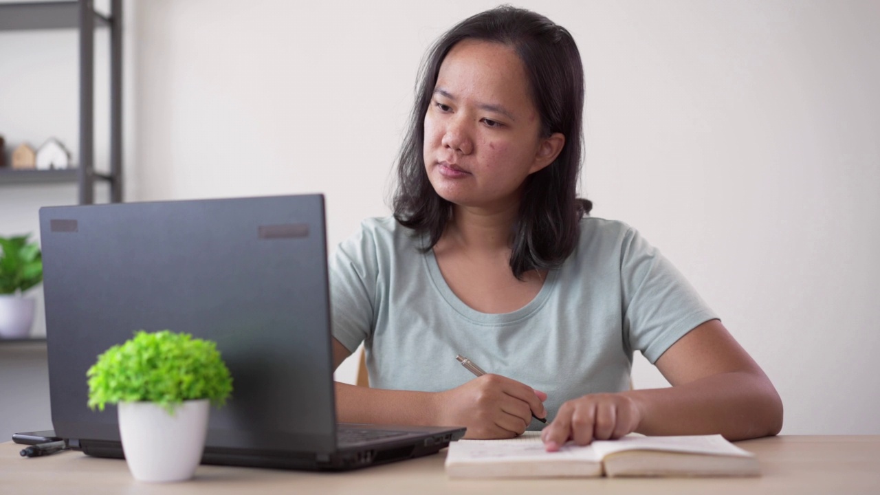 年轻的亚洲女性正在学习在线课程视频素材