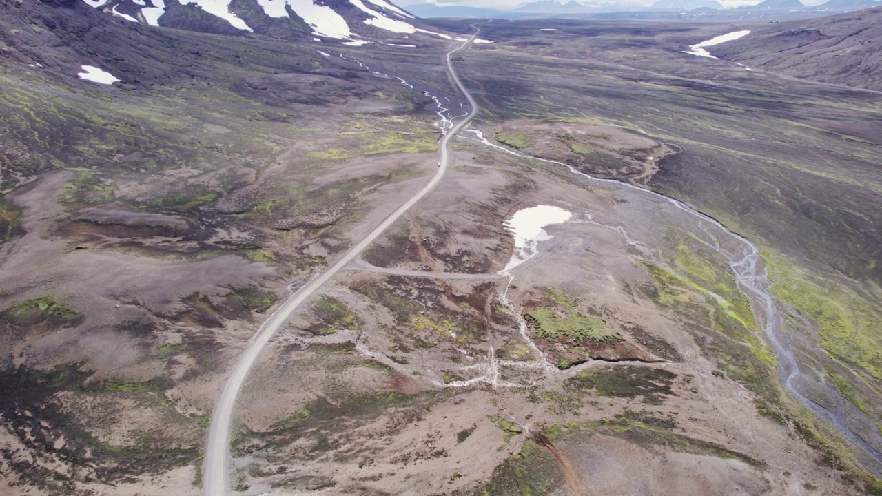 自驾游四驱车行驶在泥泞的道路上，在阳光明媚的冰岛高地的火山荒野在夏天的冰岛视频素材