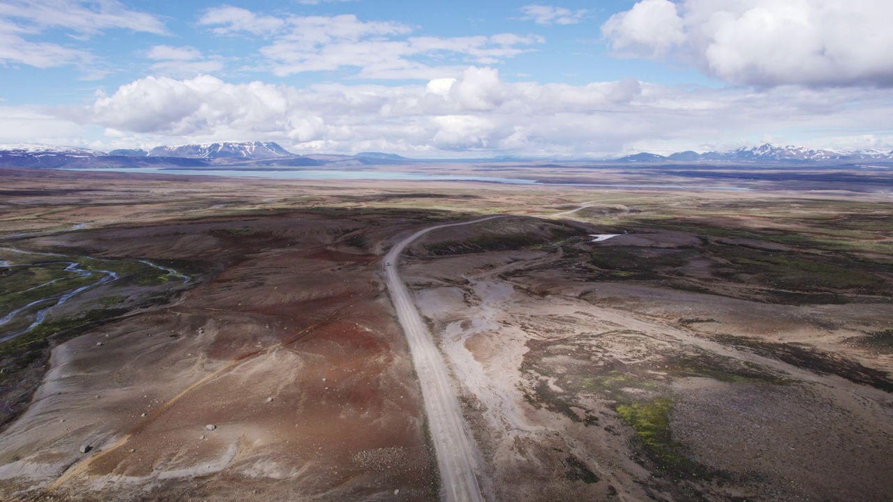 自驾游四驱车行驶在泥泞的道路上，在阳光明媚的冰岛高地的火山荒野在夏天的冰岛视频素材