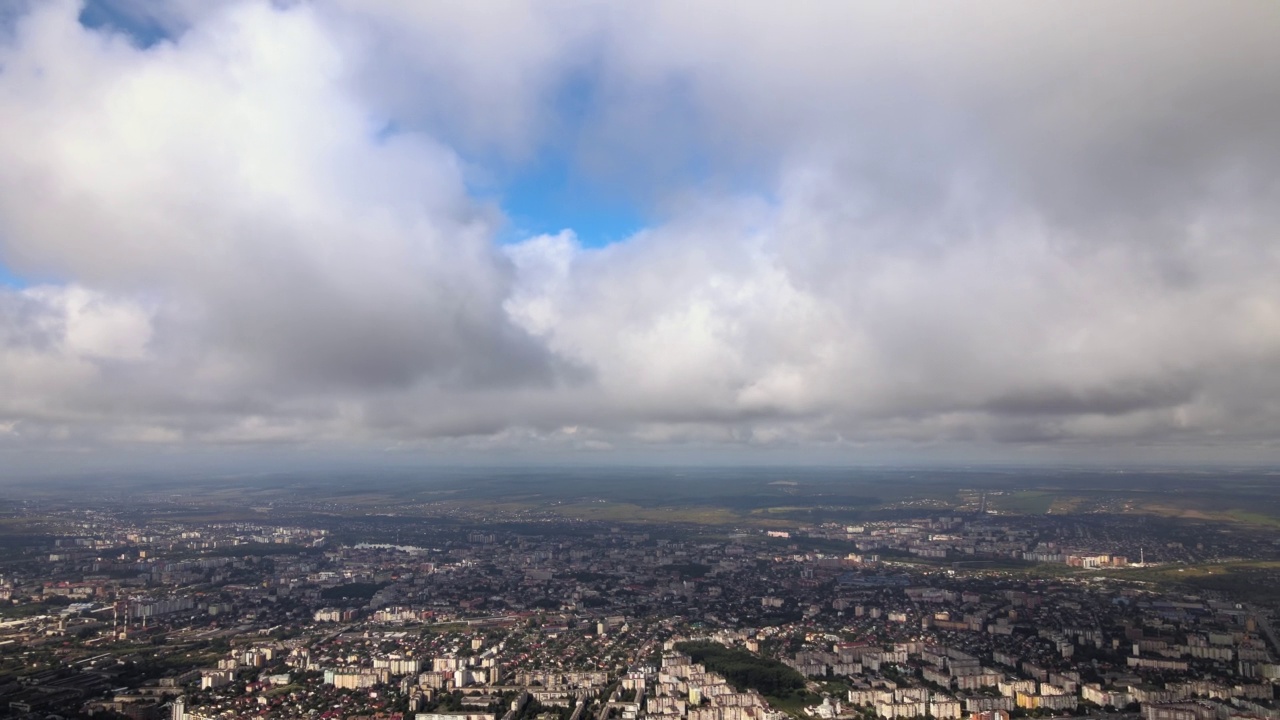 高空鸟瞰图，远处的城市被暴雨前形成的蓬松积云所覆盖视频素材